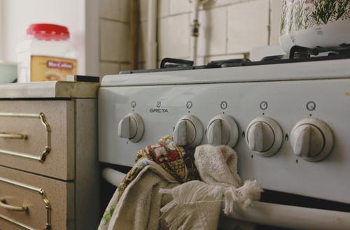 An old kitchen stove showing signs of wear and age in a kitchen An old kitchen stove showing signs of wear and age in a kitchen